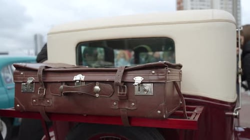 Vintage Car with Leather Suitcase in an Urban Setting