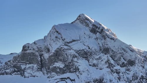 Aerial view of Fronalpstock in Kanton Glarus, Switzerland. Snow blankets the steep rocky slopes