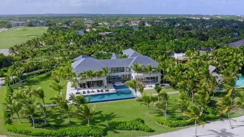 Aerial drone shot of luxury La Cana Golf Course Resort with modern villa, tropical palm trees in bea