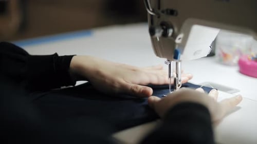 Woman Sewing Fabric on a Sewing Machine