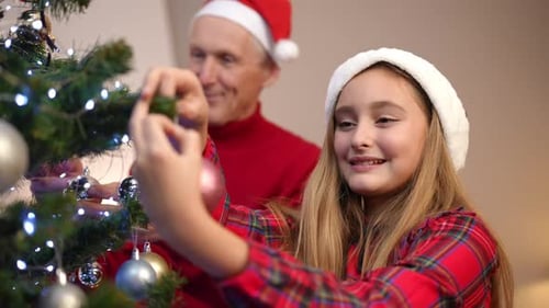 Grandfather and Granddaughter Decorate Christmas Tree Together