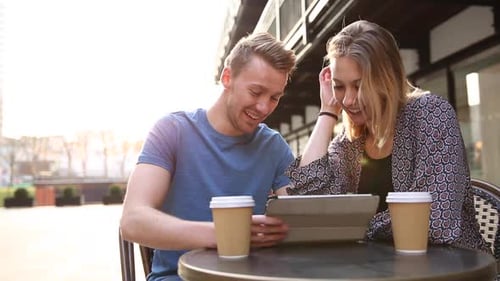 Young Couple Laughing and Talking at City Cafe