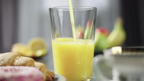 Pouring Orange Juice for a Delicious Breakfast