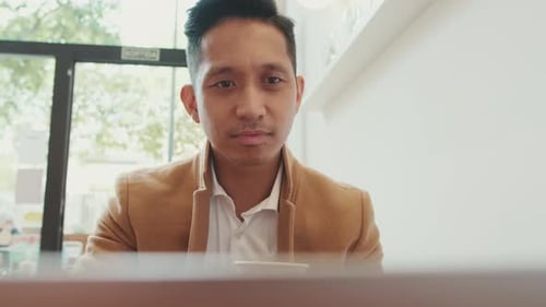 Young Adult Working on Laptop, Drinking Coffee