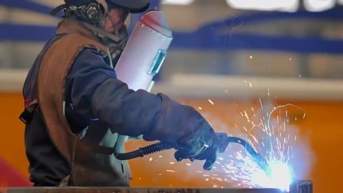 Schweißer bei der Arbeit im Schutzmaskenschweißen, Metallbauindustrie in der industriellen Produktion