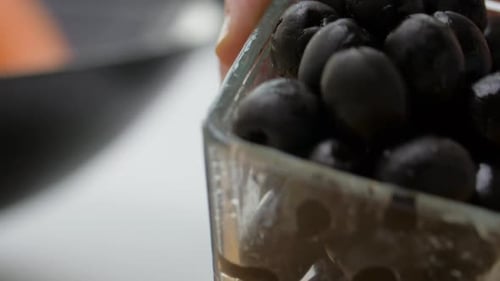 Fresh Black Olives Poured onto Wooden Cutting Board