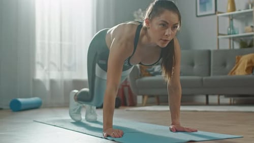 Slow Motion Close Up of a Beautiful Confident Busty Fitness Girl in an Athletic Top Doing Mountain