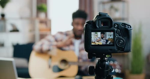 Man Plays Guitar for Camera in Living Room