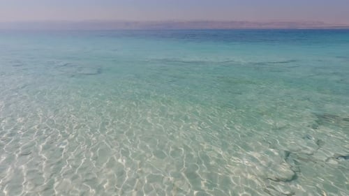 Crystal clear turquoise green blue waters with light rays shimmering, Dead Sea