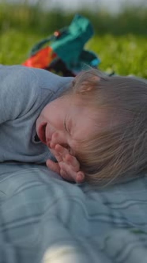 Vertical d'une petite fille d'un an et demi qui pleure lors d'un pique-nique en plein air