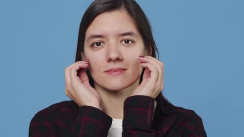 Young Woman Making Faces on Blue Background