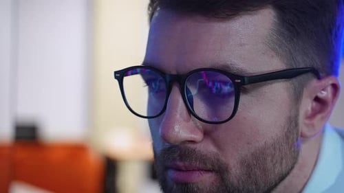 Cryptocurrency Stock Market Trader Wearing Glasses Looking at Computer Screen with Trading Charts