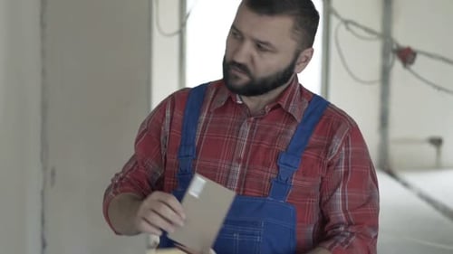 Man chooses paint colors for an interior wall