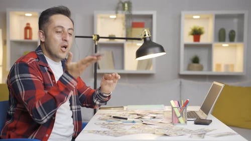 Excited Man Throwing Money in Air at Table