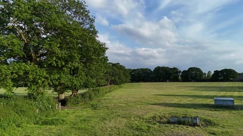 An English field in Summer, slow low footage on bright sunny day with interesting part cloudy sky