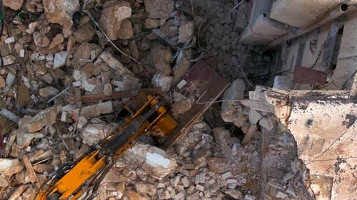 Bras d'excavateur démolissant un vieux bâtiment, vue aérienne