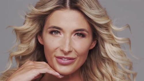 Studio Portrait of Young and Beautiful Blond Woman Over Grey Background Skin Care and Wellness