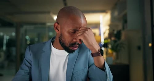 Night, frustrated and black man in office with headache, burnout or overtime fatigue in finance