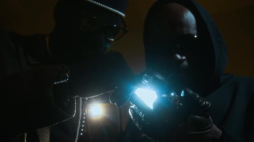 Individuals Examining Object in Dark, Dim Setting