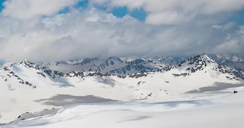 Timelapse Mountain clouds over beautiful snow-capped peaks of mountains and glaciers.