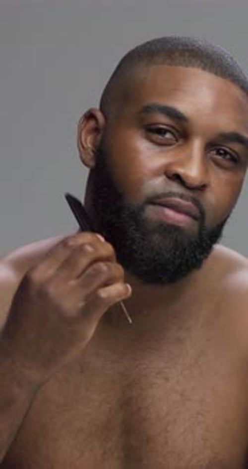 Self care, face and man with comb for beard, grooming and maintenance of hair, studio and morning