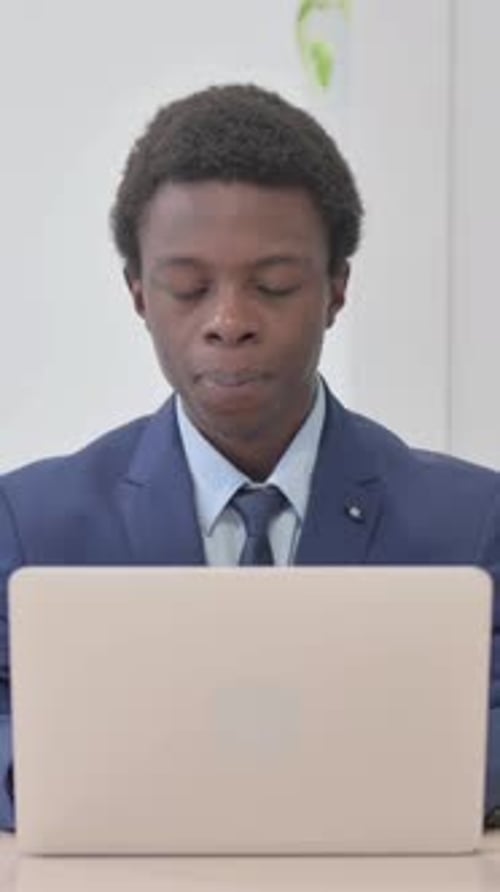 Young Man in Suit Talking on Laptop