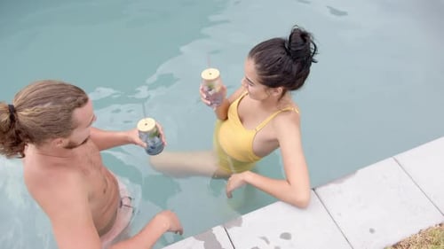 Couple Enjoying Drinks in the Swimming Pool Together