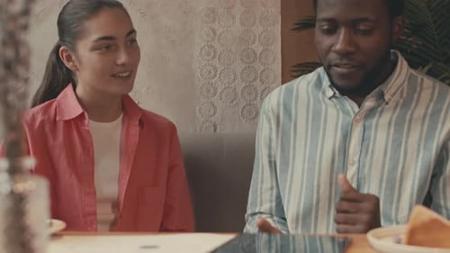 Man and Woman Discussing Data on a Tablet