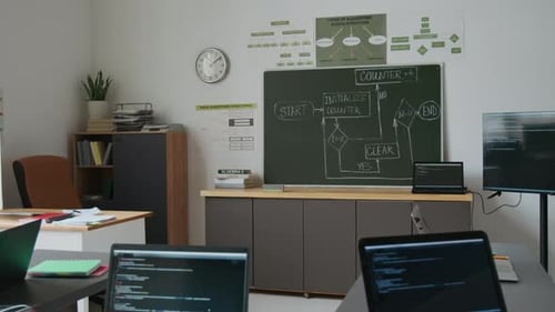Interior of Computer Science Classroom with Laptops Displaying Code
