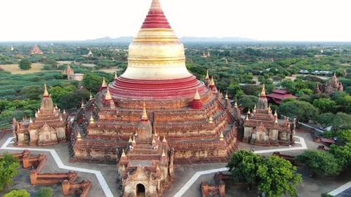 Ancient Buddhist temple in Bagan, Myanmar with more in background. Aerial drone shot.