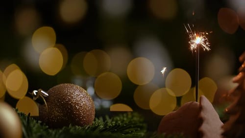 Festive Sparkler and Christmas Ornaments Close-Up
