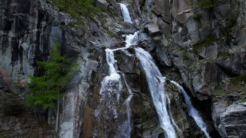 4k Drone Shoots Slow Ascent Up Cascading Waterfall Nestled In between Mountain Landscape With Pine T