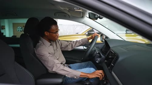 Man Testing Car Interior and Controls in Dealership