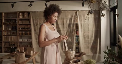 Contenido: Mujer empacando un producto ecológico por pedido