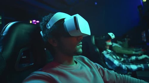 People in VR Headsets Playing Games at Night
