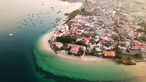 4k drone footage of a coastal city and boats in the ocean