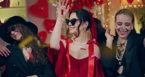 Happy Women Dancing at Party with Confetti