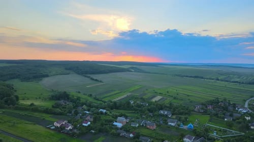 Aerial Landscape View of Village Houses and Distant Green Cultivated Agricultural Fields with