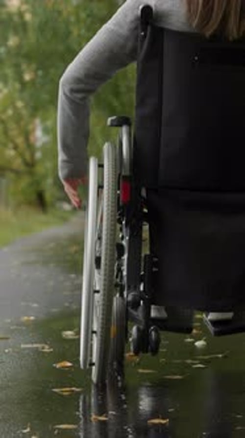 Woman with Spinal Cord Injury Moving Along Asphalt Road