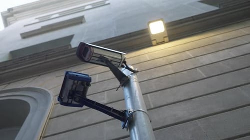 Security Camera on Pole Against Building Facade