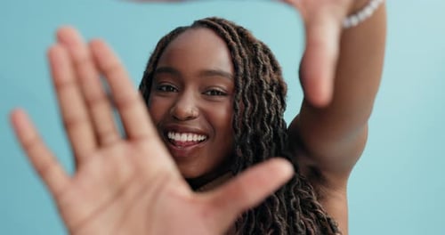 Smiling Woman Framing Face with Hands in Studio