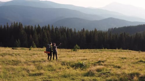 Couple of tourists walks up on hill. Majestic Carpathian Mountains. Beautiful landscape of untouched