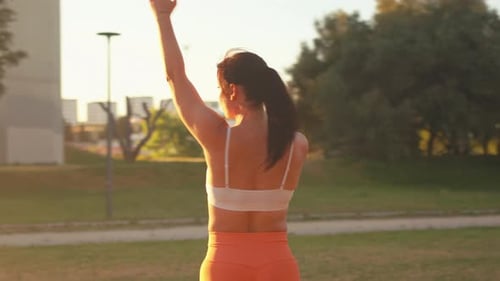 Sporty Fit Woman Doing Arm Exercises at City Park During Sunny Day