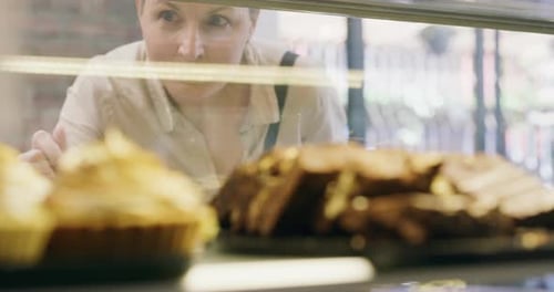 A mature woman choosing a treat in a bakery