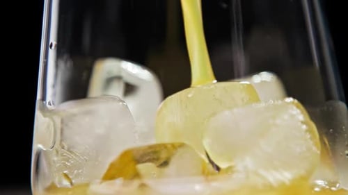 Juice Being Poured Over Ice in Glass