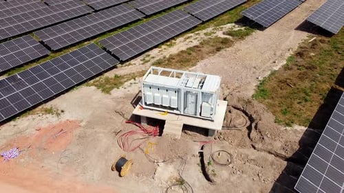 Aerial orbit view of MV inverter station and cabling reel at a solar field