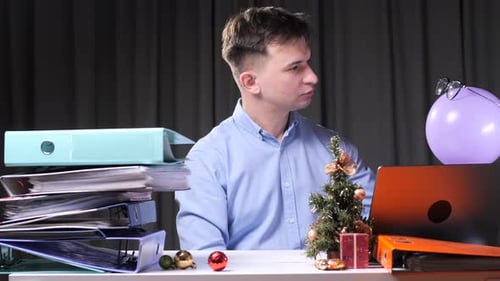 Office Worker Looking at Floating Balloon and Glasses During Christmas Time