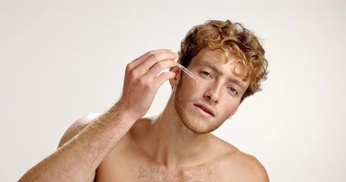 Serum, skincare and face of man in studio for vitamin c, beauty and facial treatment