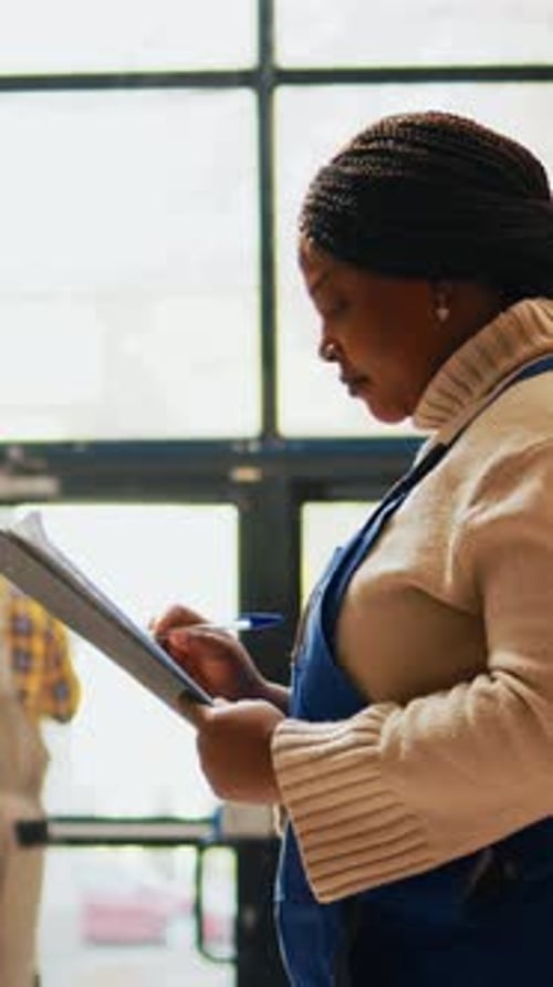 Woman Writes on Clipboard at Work