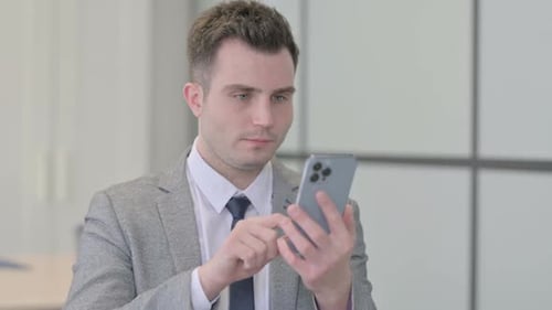 Young Adult Using Smartphone in Office Setting